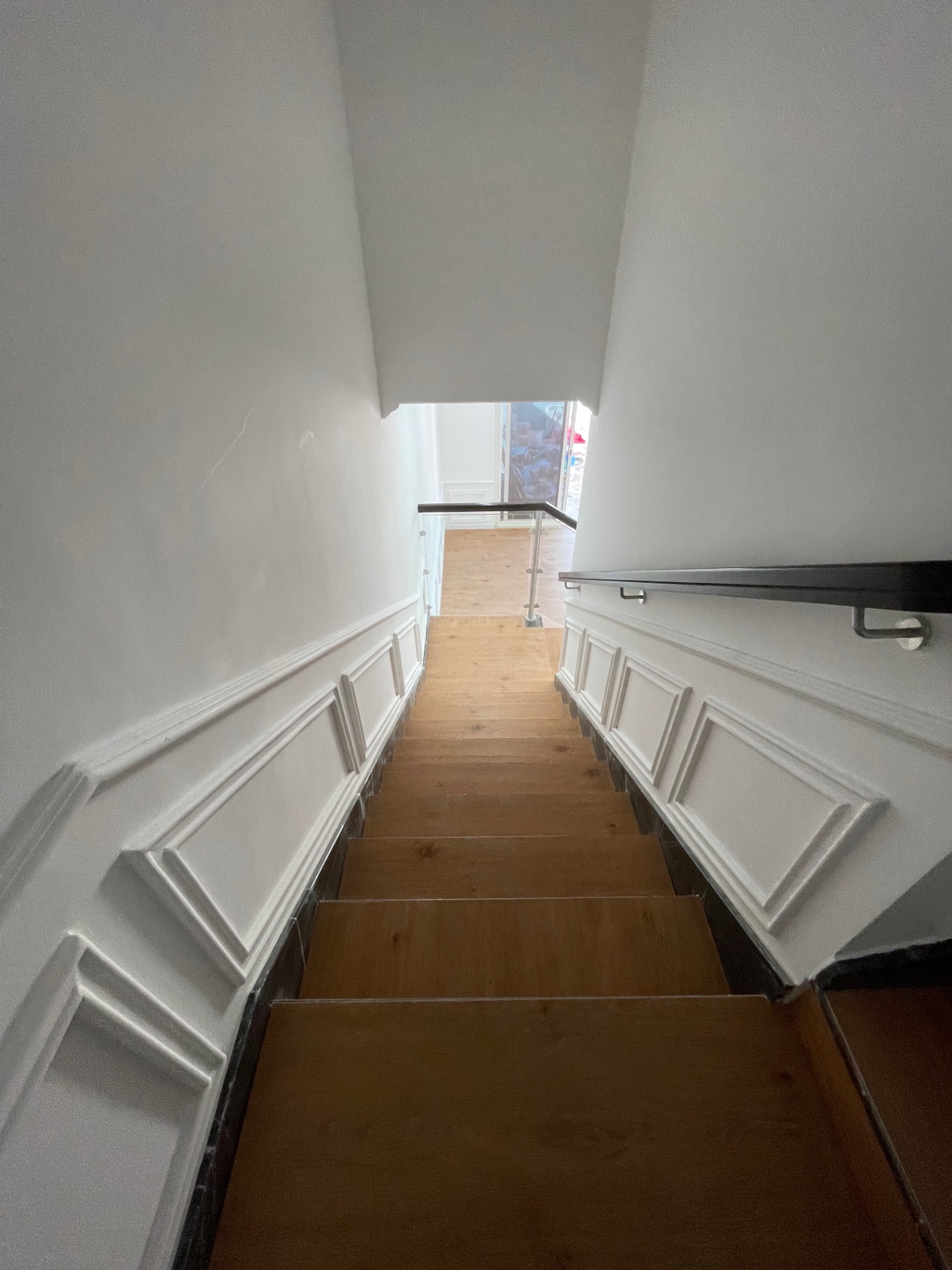 Staircase with panelled walls and dark timber handrail — residential renovation in the Netherlands by Ab & Zen Interior