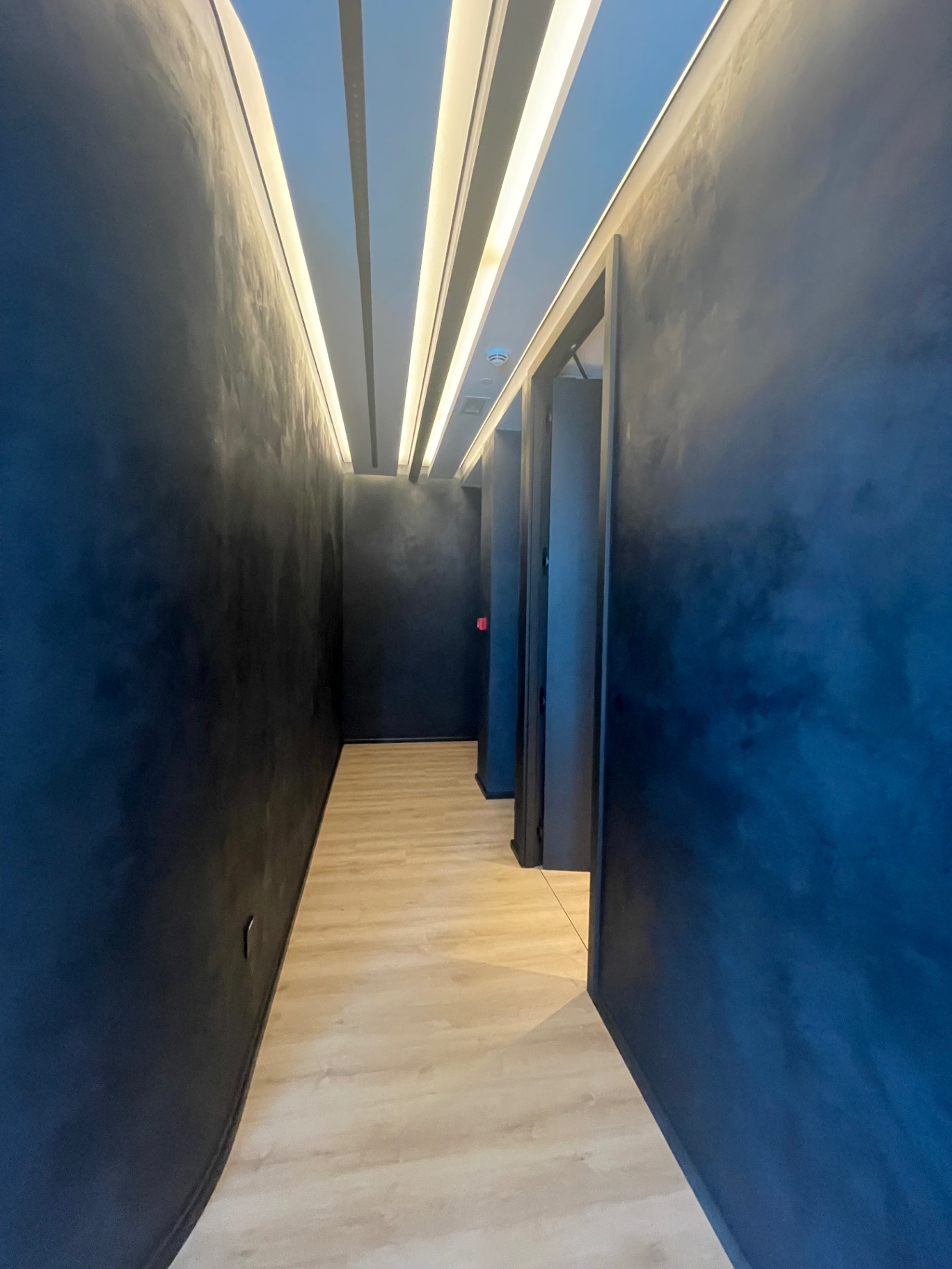 Micro-cement corridor with concealed cove lighting — complete fit-out execution and handover by Ab & Zen Interior