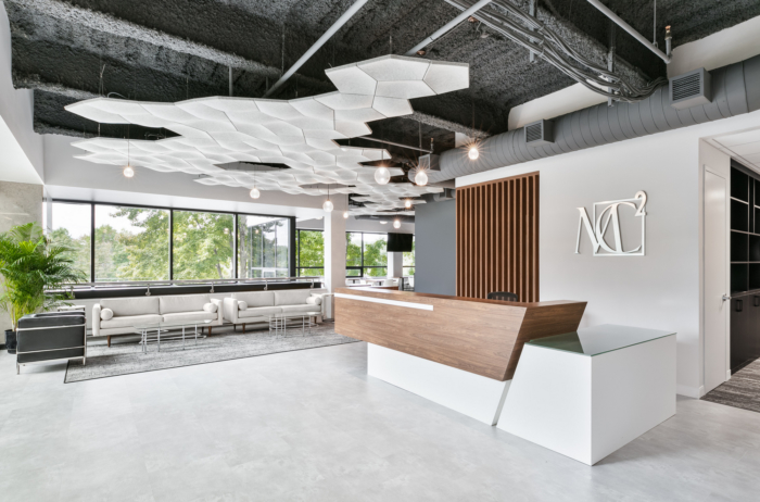 Sculptural acoustic ceiling & angular reception desk — commercial interior design by Ab & Zen Interior